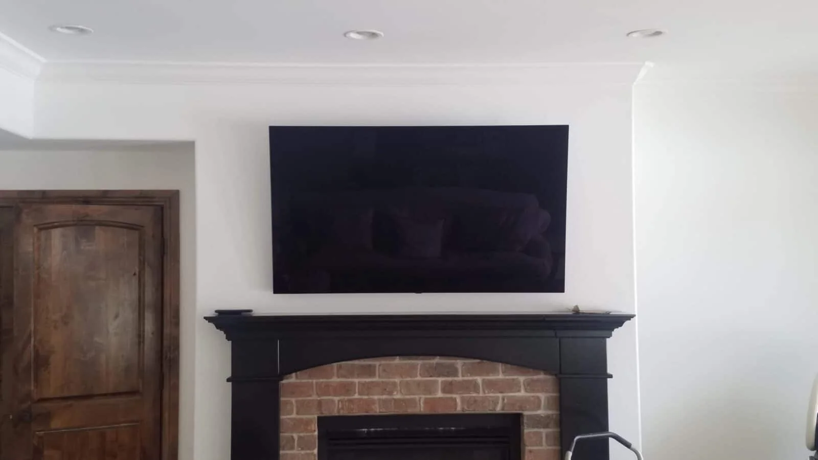 TV mounted above a traditional brick fireplace