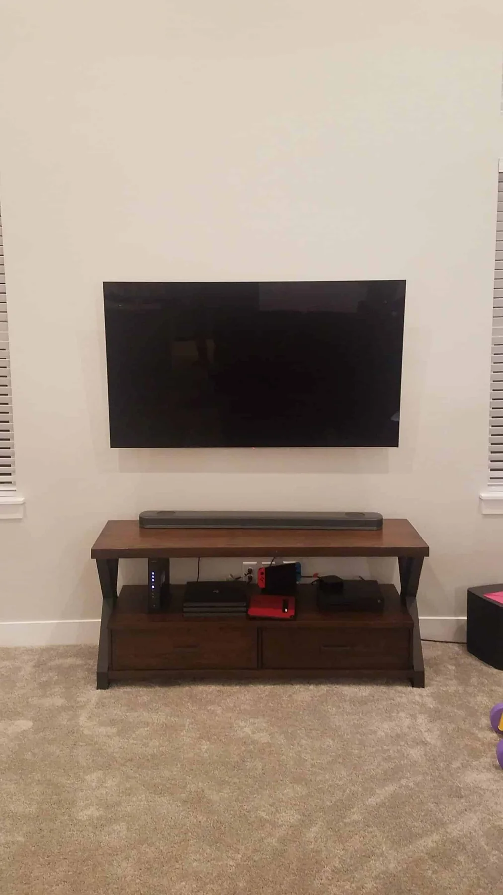 TV mounted above a low media console and soundbar