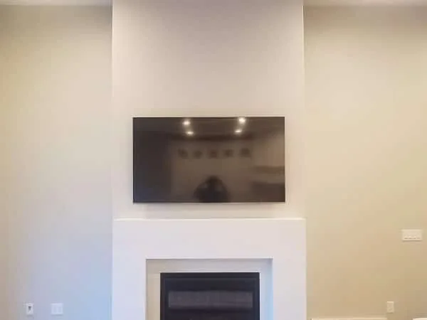 TV recessed above a minimalist white fireplace wall
