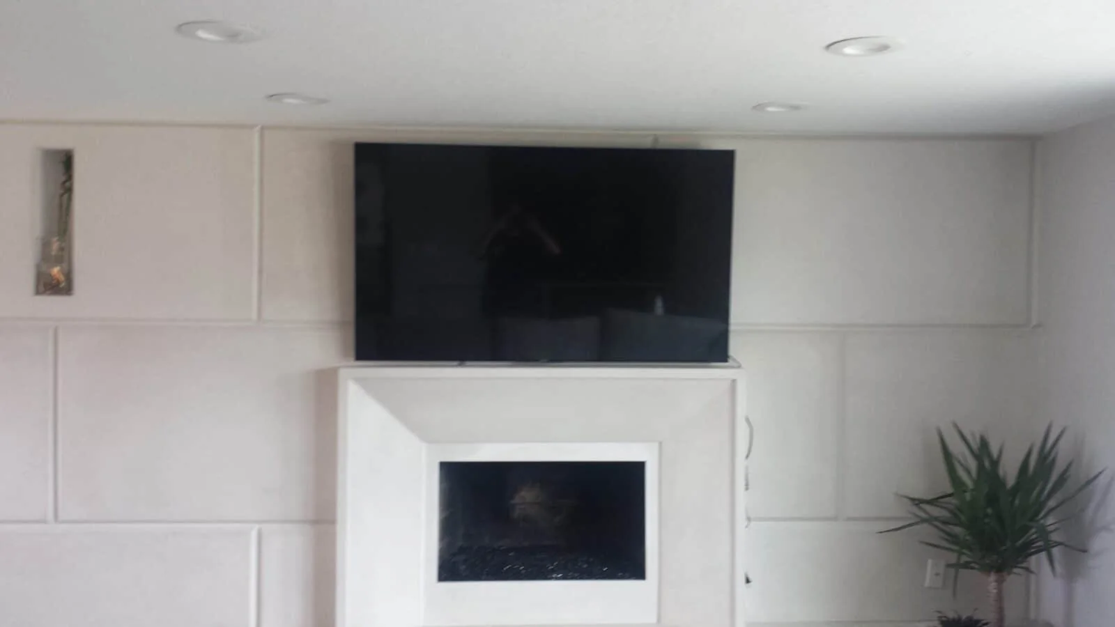 Large TV mounted above a modern fireplace