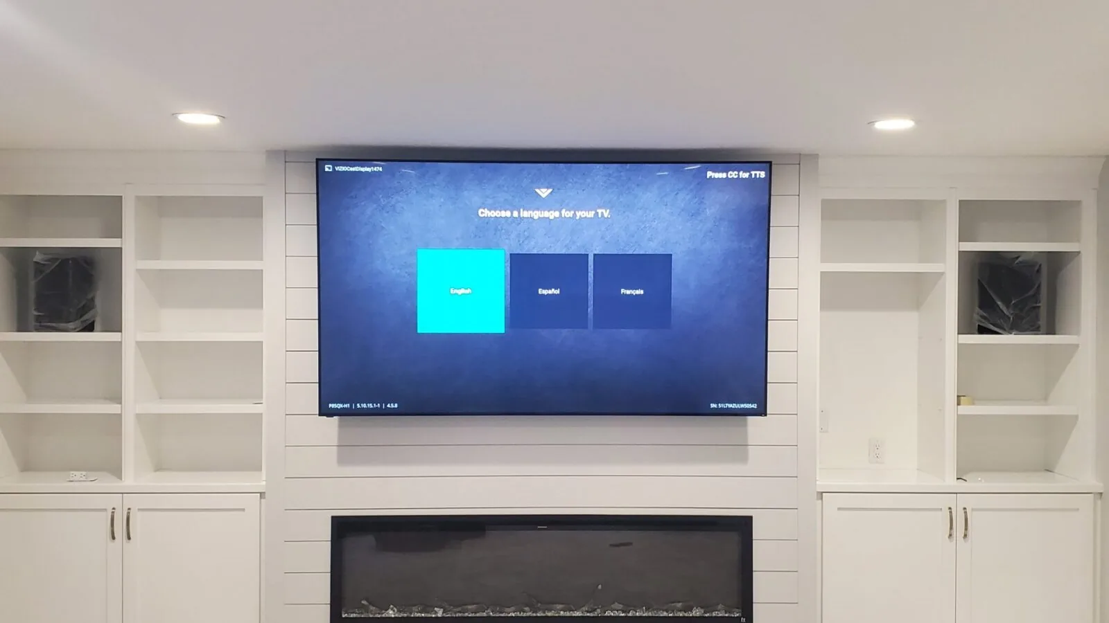 Finished television installation above a modern fireplace
