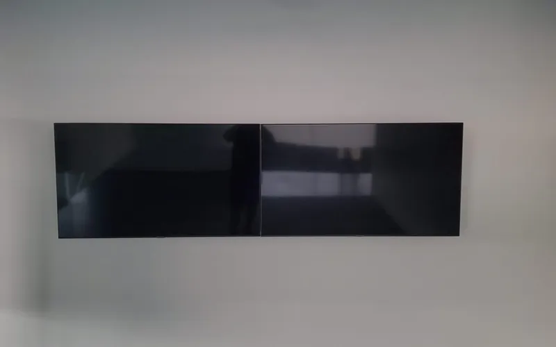 Two wall-mounted commercial displays aligned side by side