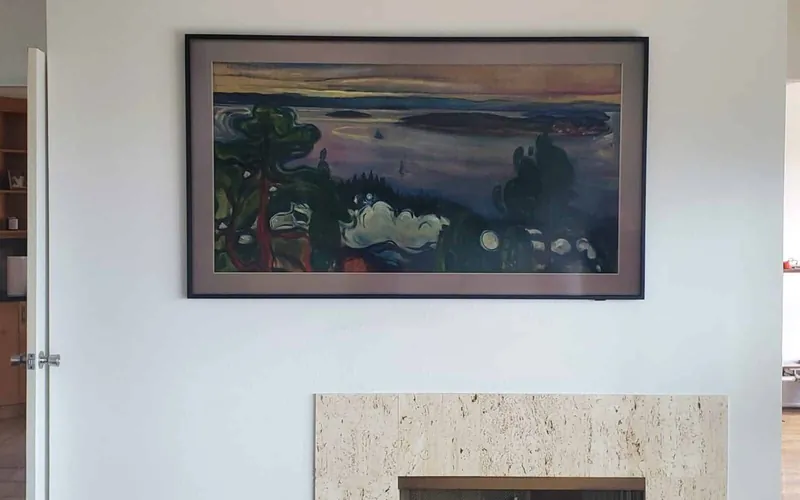 Frame-style television mounted above a fireplace